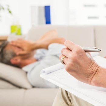 Therapist listening to male patient and taking notes in the office Psicologia das emergências: cuidado emocional em situações de trauma e crise
